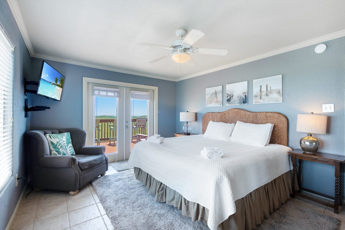 Your coastal bedroom retreat features crisp white linens, wicker headboard, and French doors opening to your private balcony overlooking endless views.