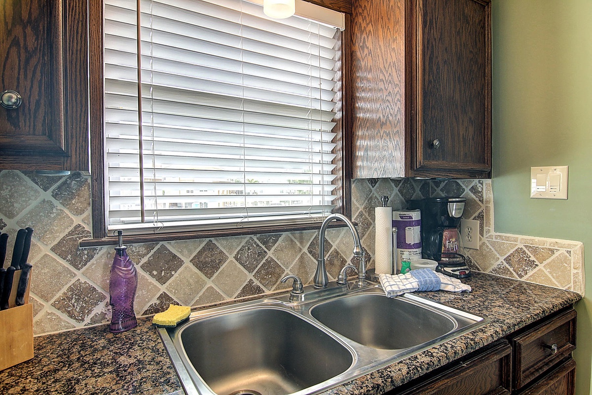 Your fully-equipped kitchen awaits with granite counters, stylish tile backsplash, and everything needed to prepare meals during your stay.