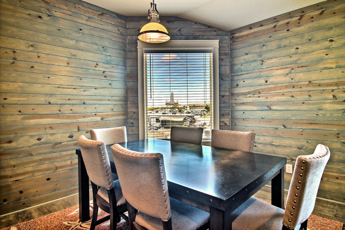 Your rustic dining nook features rich wood walls and marina views through large windows—perfect for memorable meals.