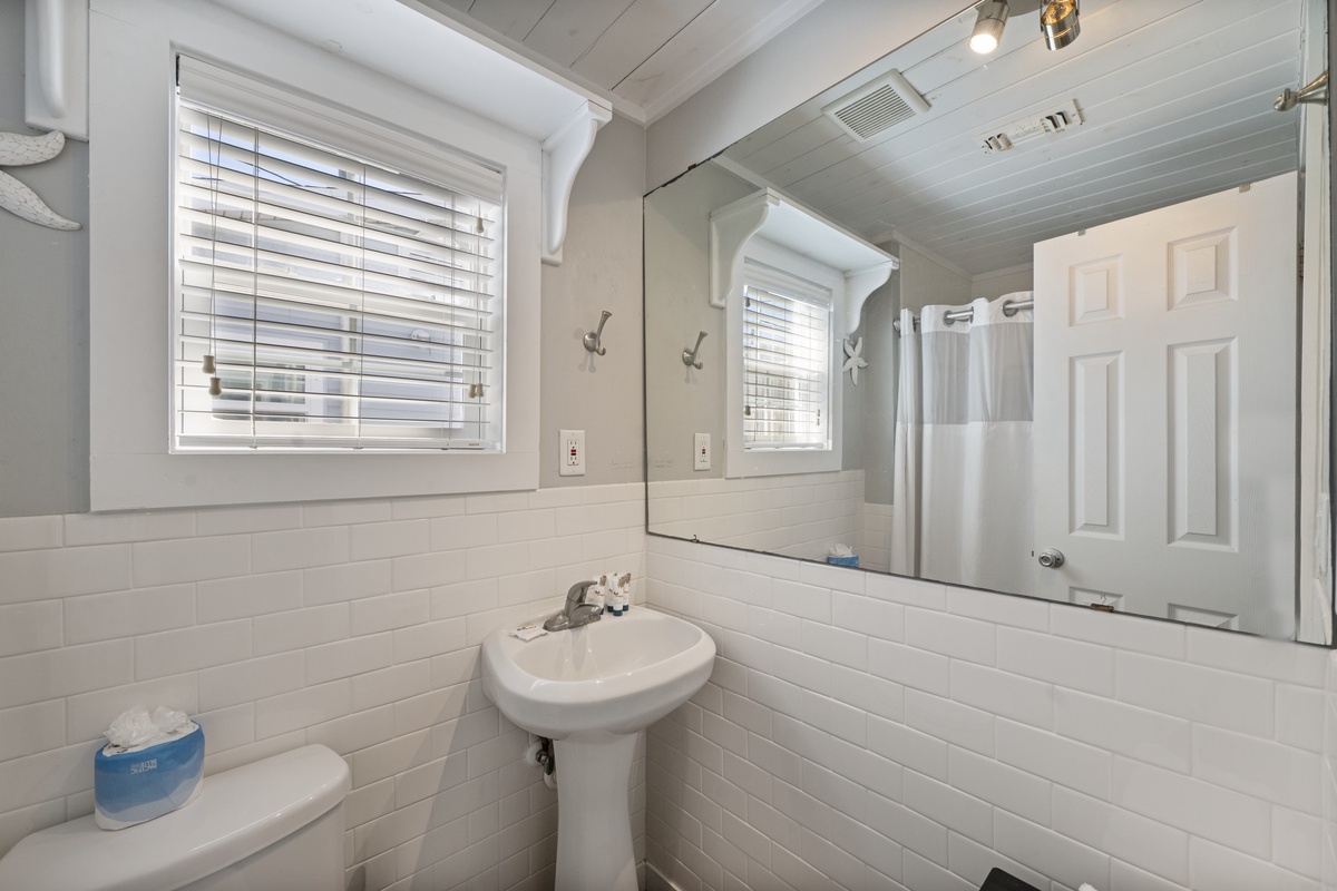 Your bright, clean bathroom features classic subway tile, natural light from the window, and all the essentials for a refreshing start to each day.