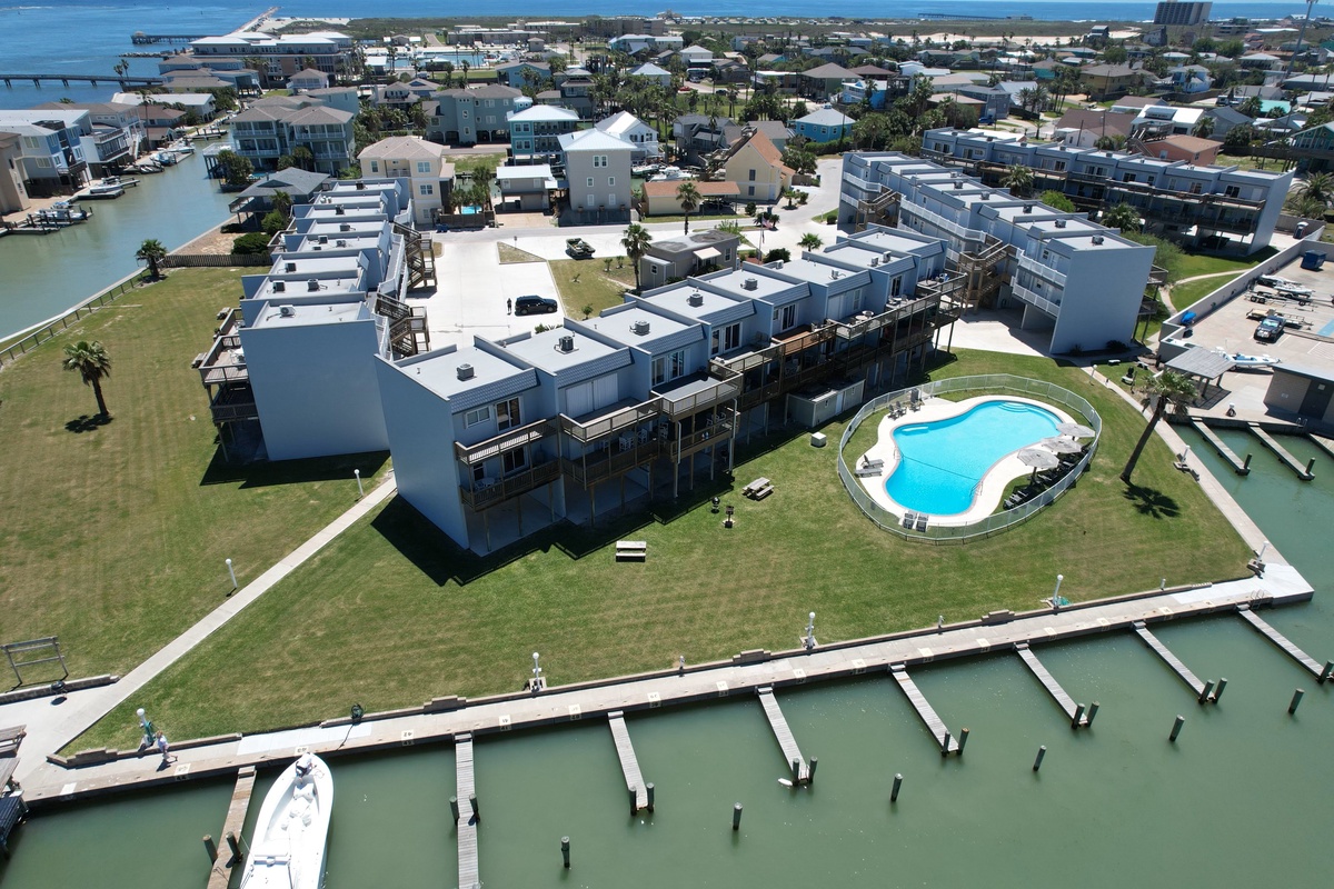 Modern waterfront complex featuring contemporary apartments, sparkling pool, and private marina docks on Florida's scenic coastline.