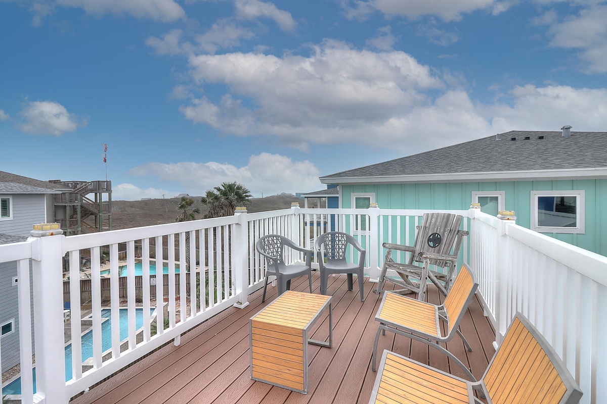 Relax on your private deck with poolside views, comfortable seating, and coastal charm surrounding you.