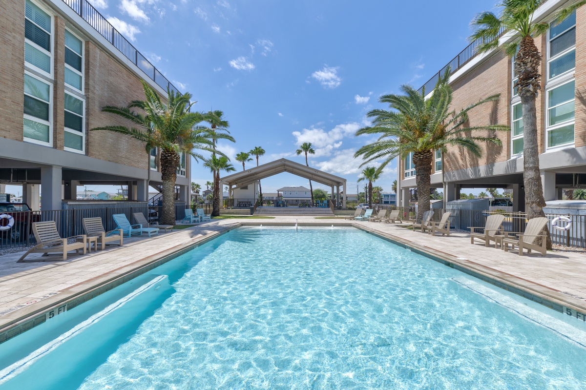 Dive into crystal-clear waters surrounded by swaying palms and modern comfort. Your perfect poolside retreat awaits under endless blue skies.