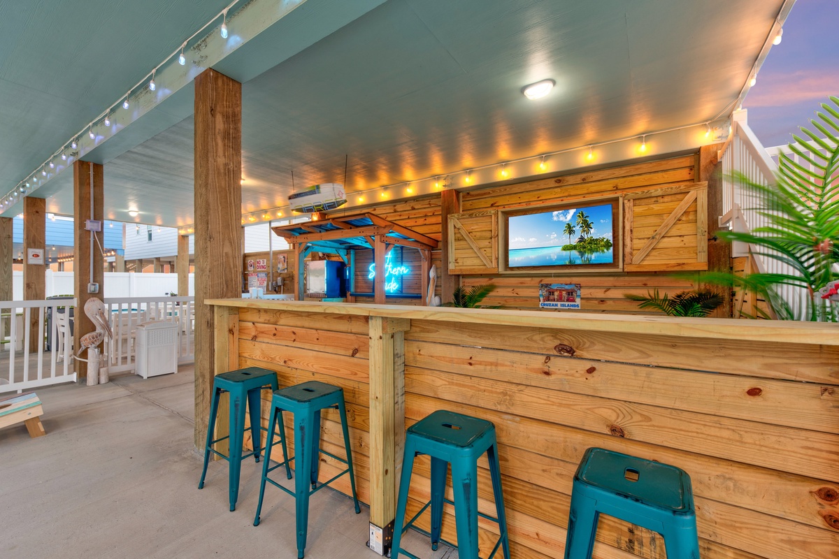 Unwind at your private tiki bar with tropical vibes, perfect for evening cocktails while watching the sunset unfold on screen.