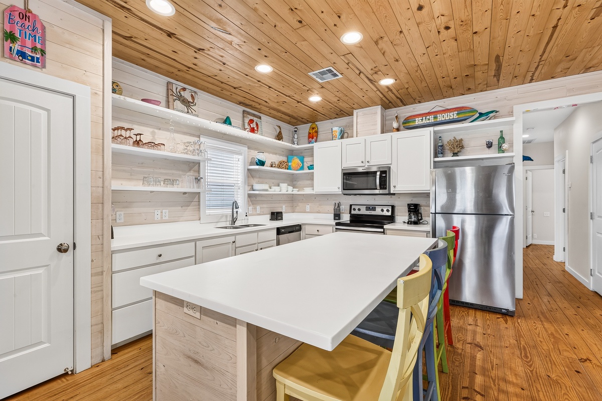Your beach-inspired kitchen features warm wood ceilings, a spacious island for gathering, and all the appliances you need to whip up delicious meals during your stay.