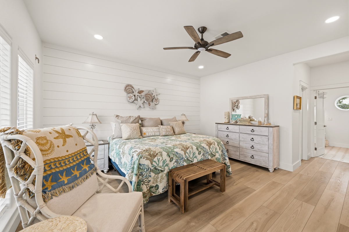 Drift off in coastal serenity surrounded by soft linens, shiplap accents, and tropical touches that invite pure relaxation into your retreat.