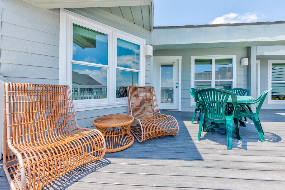 Relax on your private deck with stylish wicker seating and outdoor dining space, perfect for morning coffee or sunset meals.