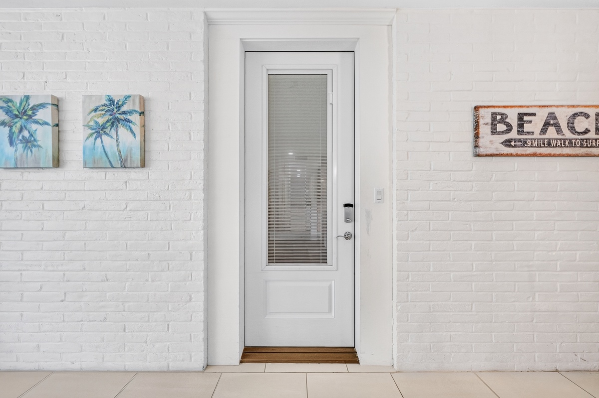 Bright white brick surrounds this entrance, welcoming you with coastal charm and a hint of seaside adventure just beyond the door.
