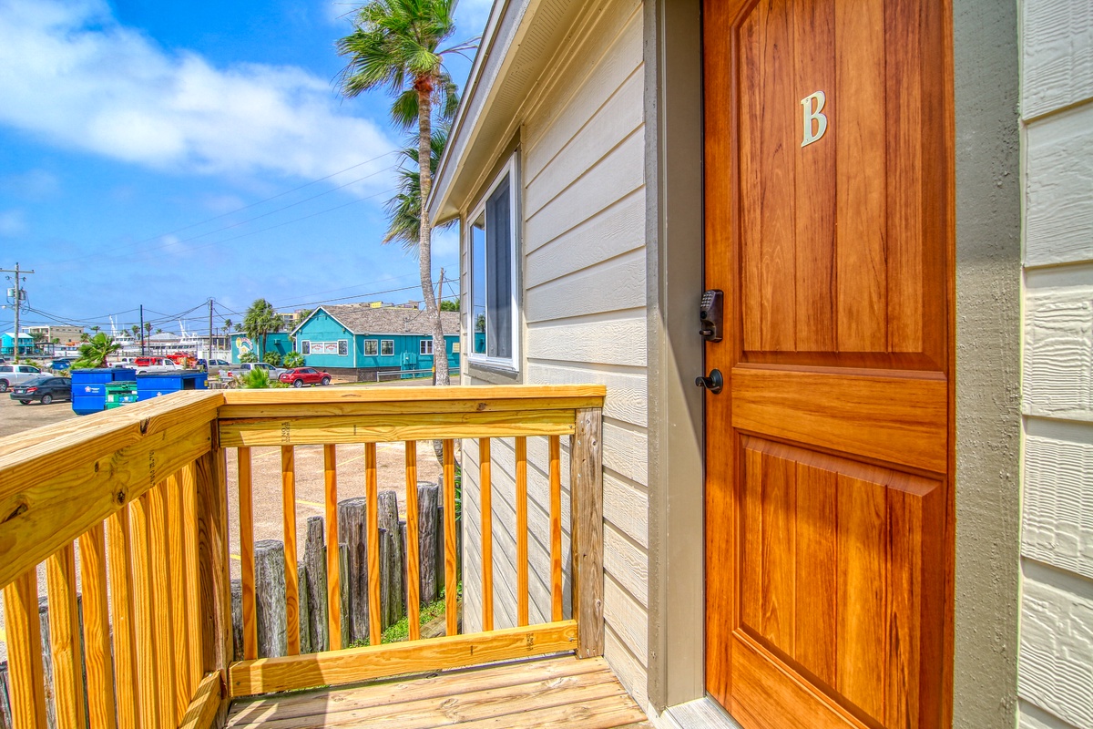 Charming coastal cottage entrance with tropical palms and colorful neighborhood views in a relaxed beach community setting.