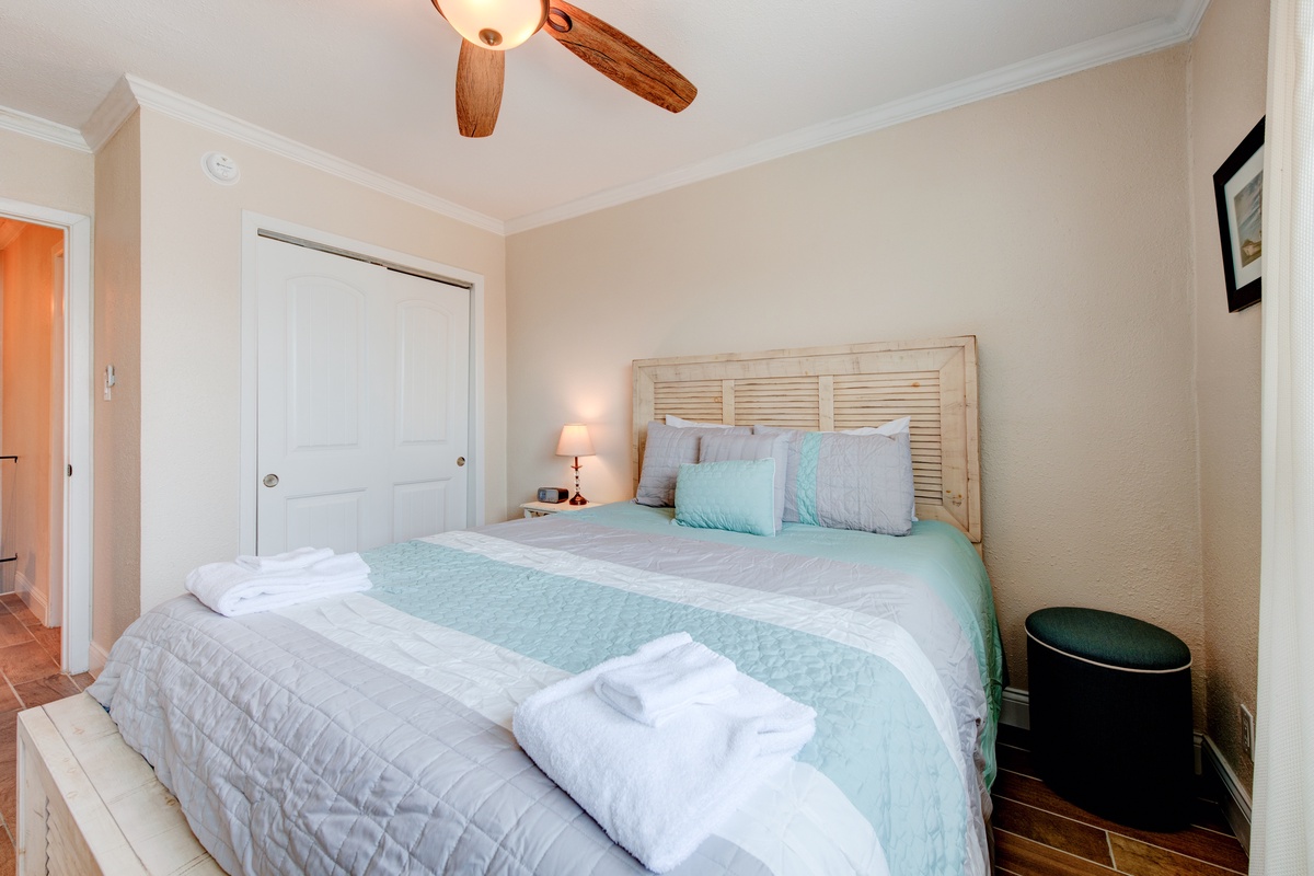 Drift off peacefully in your cozy bedroom featuring soft linens and gentle ceiling fan breeze for ultimate comfort.