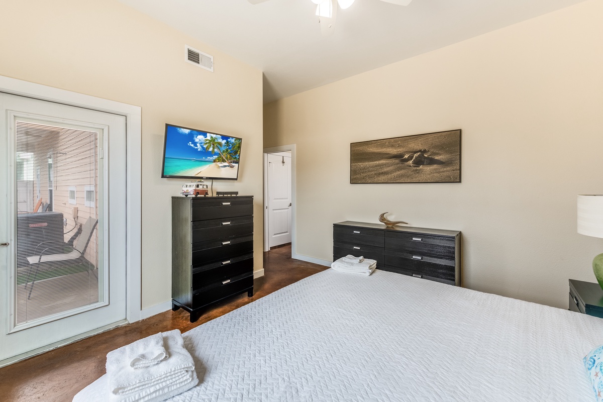 Relax in your spacious bedroom with modern amenities, wall-mounted TV, and private balcony access for peaceful moments.
