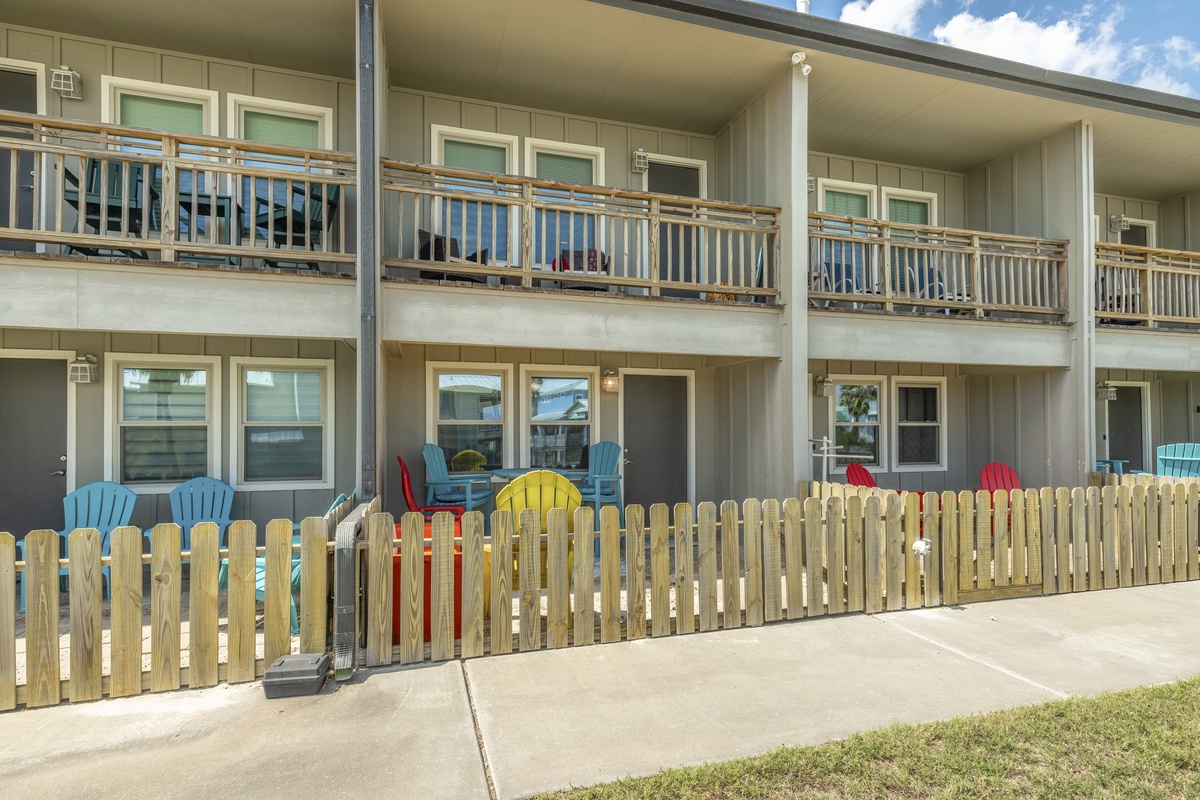 Charming two-story building features private patios with colorful Adirondack chairs where you can unwind after exploring the area.