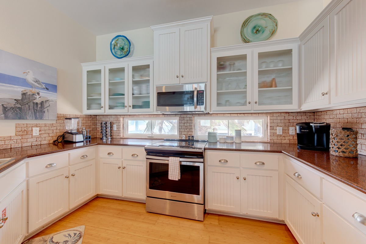 Cook your favorite meals in this bright, fully-equipped kitchen with granite counters, modern appliances, and charming coastal touches.
