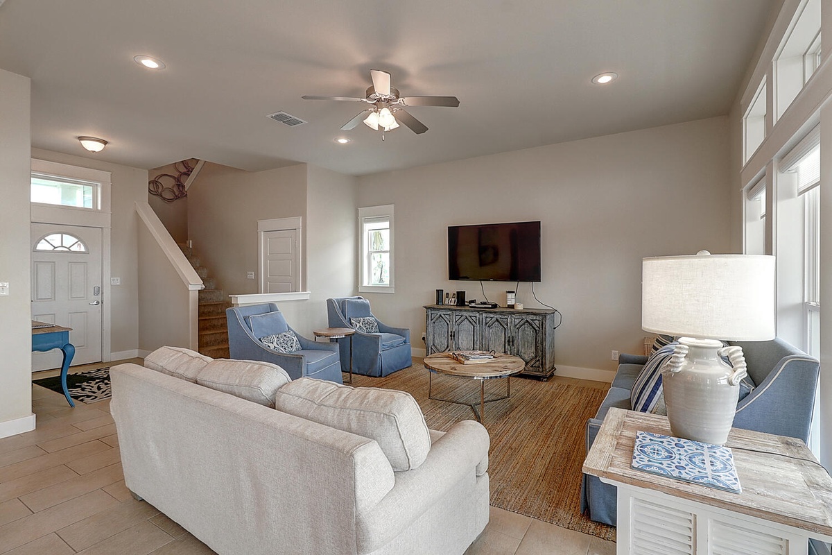 Relax in your spacious living room featuring comfortable seating, flatscreen TV, and coastal-inspired décor that creates the perfect gathering space for your vacation.