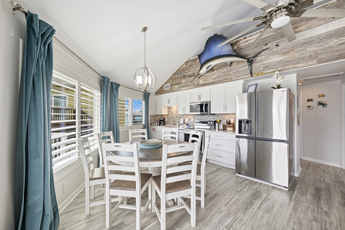 Your coastal kitchen awaits with modern appliances, nautical touches, and a dining table perfect for morning coffee or evening meals together.