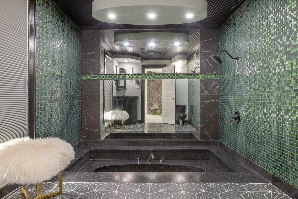 Luxuriate in your stunning spa-style bathroom with shimmer mosaic tiles, sunken tub, and elegant modern design.