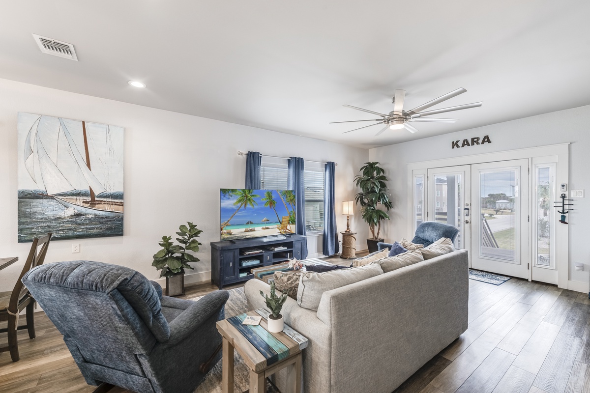 Gather together in the inviting living room, featuring comfortable seating, a large TV, and plenty of space to relax after a day of coastal adventures.