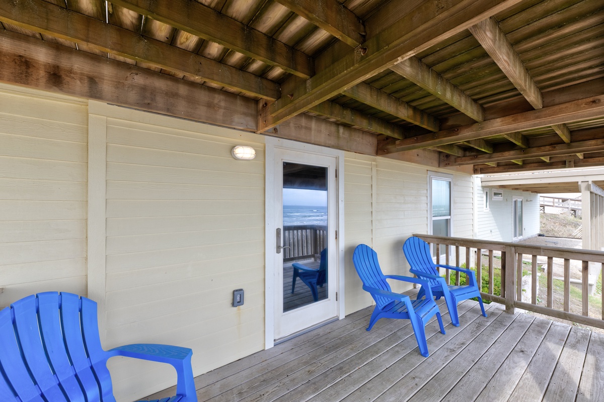 Settle into your private balcony with bright blue Adirondack chairs, where ocean breezes and stunning views create the perfect coastal retreat.