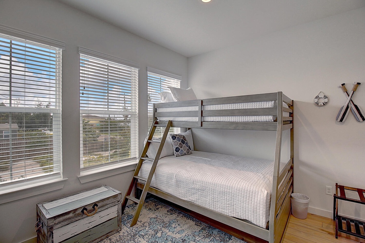 Your kids will love this cozy bunk room with natural light streaming through blinds and nautical touches that spark adventure dreams.