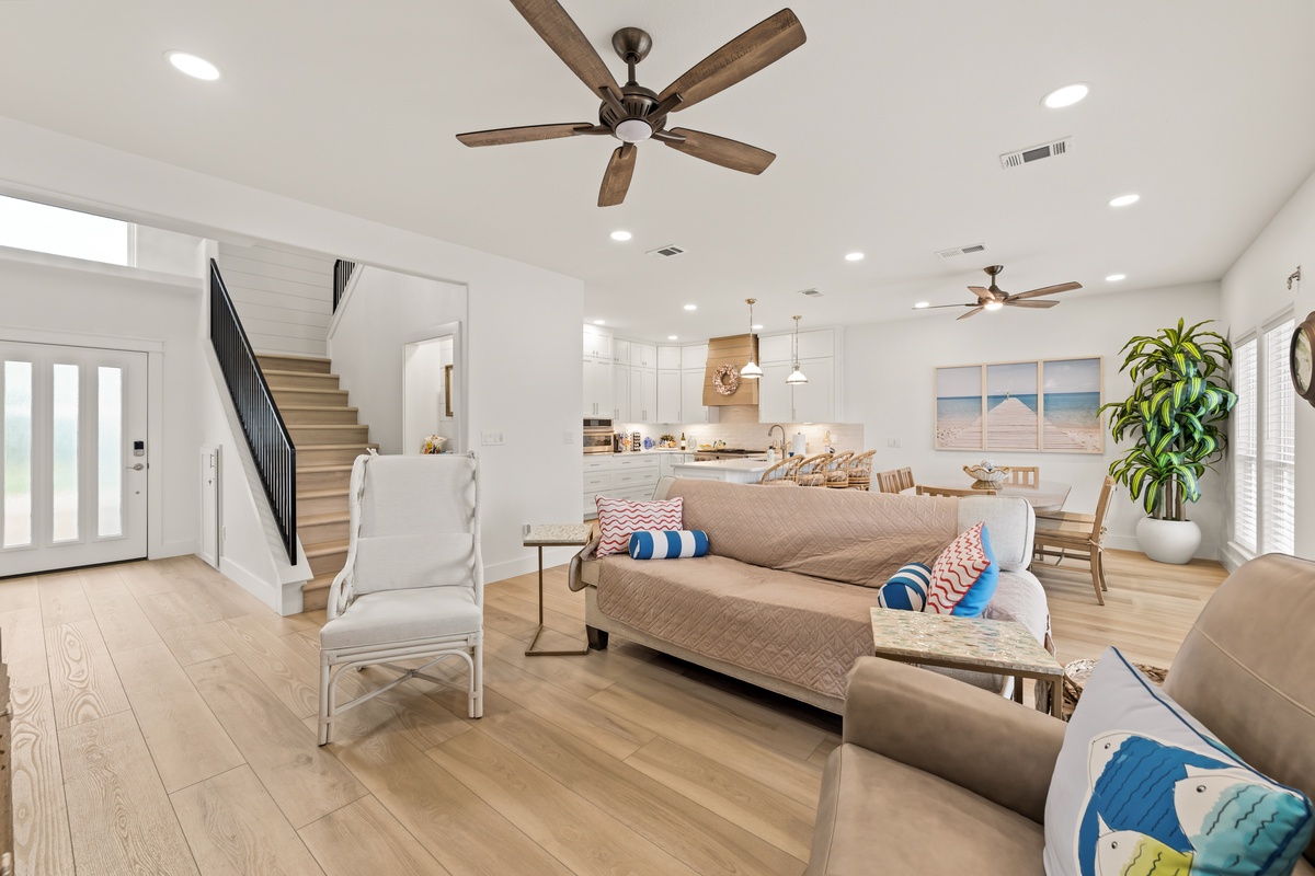 Relax in this bright, airy living space where coastal charm meets modern comfort. Cozy seating invites you to unwind while gentle ceiling fans keep the space refreshed and welcoming.