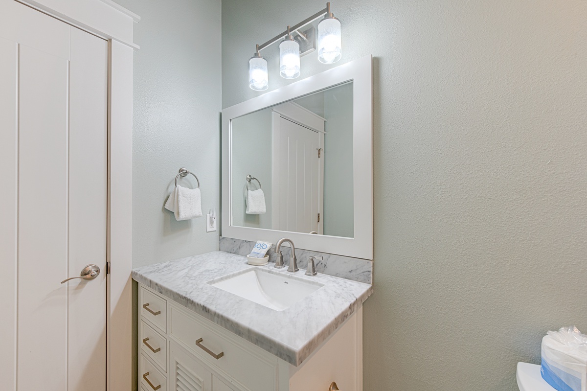 Step into your elegantly appointed bathroom featuring a beautiful marble vanity, premium lighting, and fresh towels awaiting your arrival.