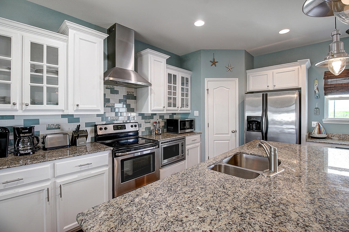 Your spacious coastal kitchen features granite counters, stainless appliances, and charming nautical touches perfect for preparing memorable meals.