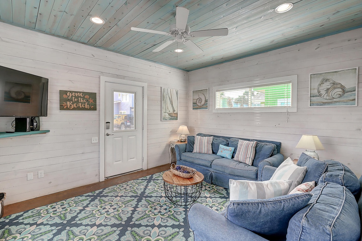 Sink into plush coastal comfort where shiplap walls and ocean-inspired décor create your perfect seaside retreat.