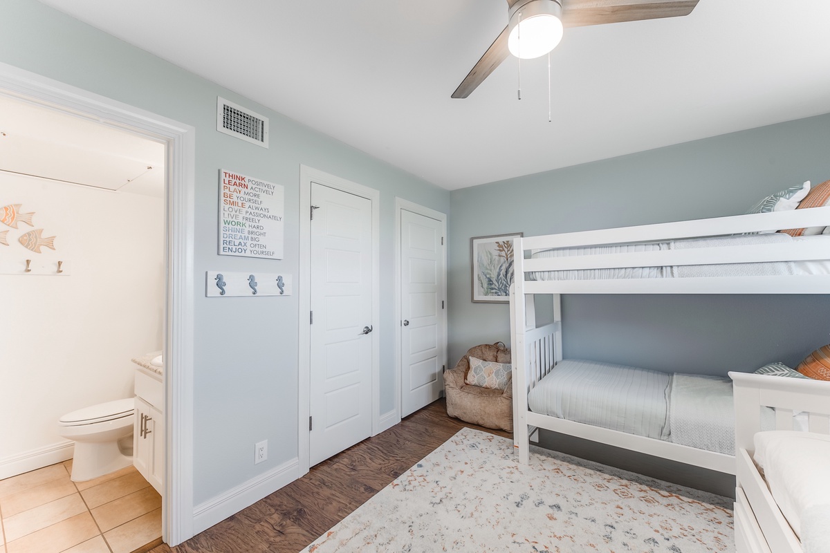 Your kids will love this cozy bunk room with its playful beach-themed decor and convenient ensuite bathroom right next door.