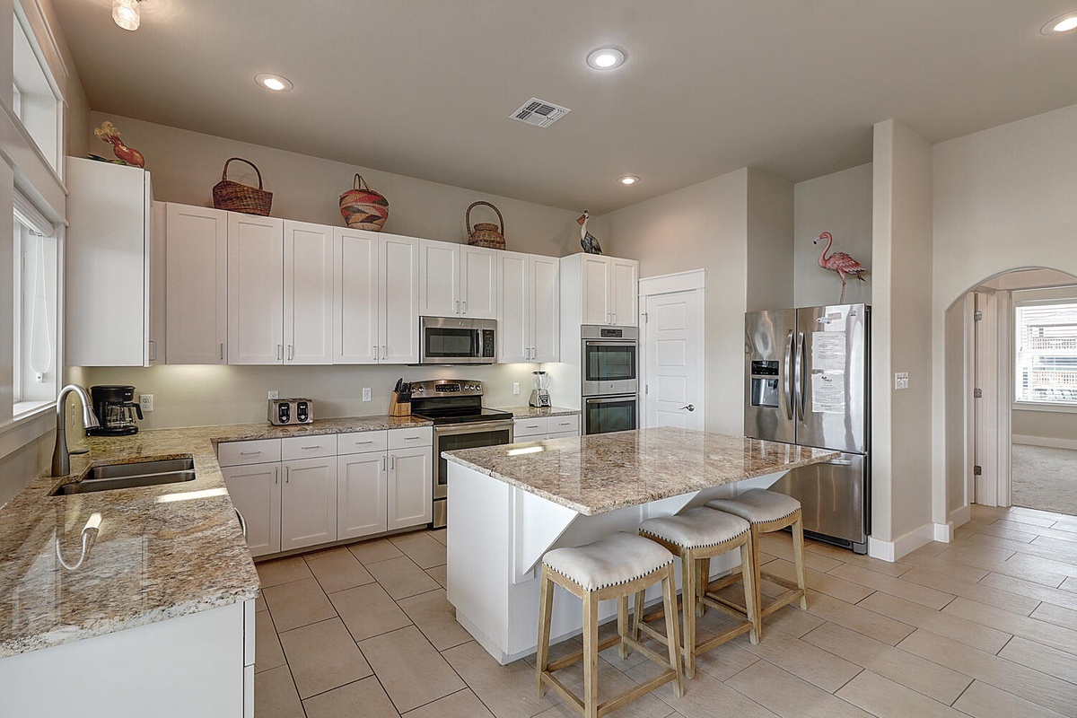 Your spacious kitchen features granite countertops, modern appliances, and a convenient island with seating for casual dining and prep work.