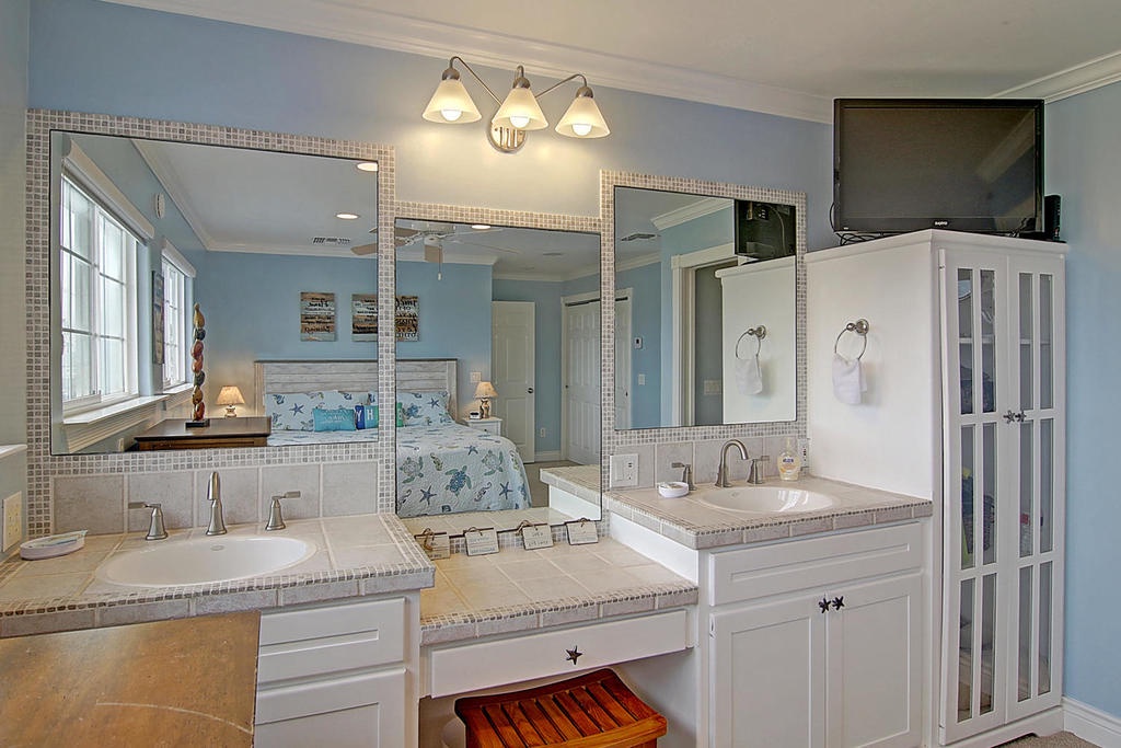 Indulge in your spacious master suite with dual vanities, soaking tub, and elegant coastal touches for ultimate relaxation.