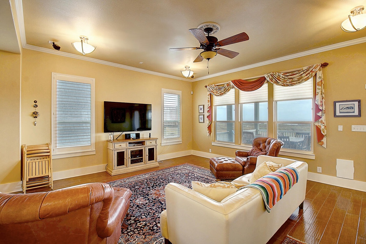 Relax in your bright living room with leather seating, big-screen TV, and stunning water views through expansive windows.