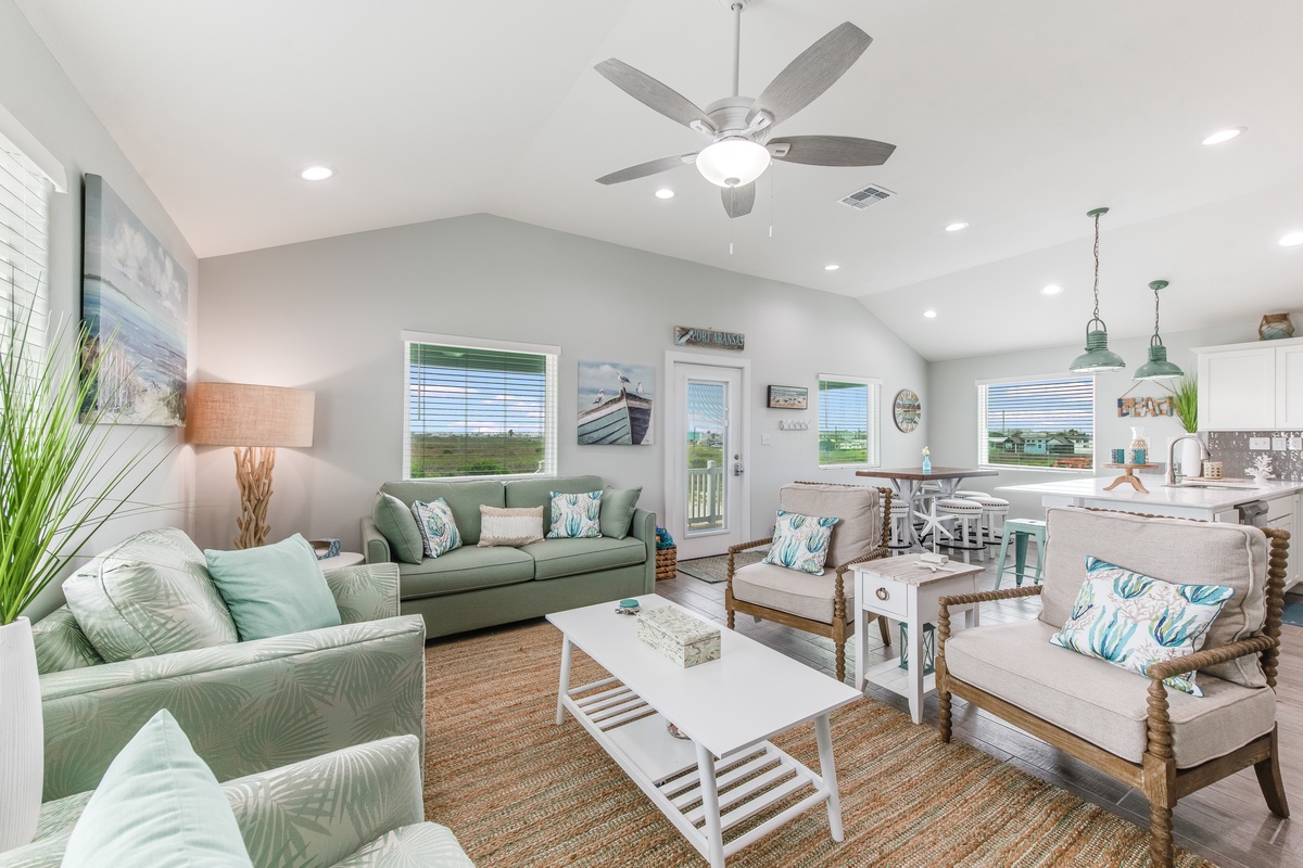 Unwind in this bright, coastal-inspired living space where soft seafoam sofas and beach-themed decor create your perfect vacation retreat.