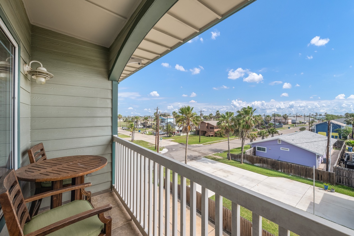Relax on your private covered balcony with comfortable seating while enjoying peaceful neighborhood views and refreshing coastal breezes.