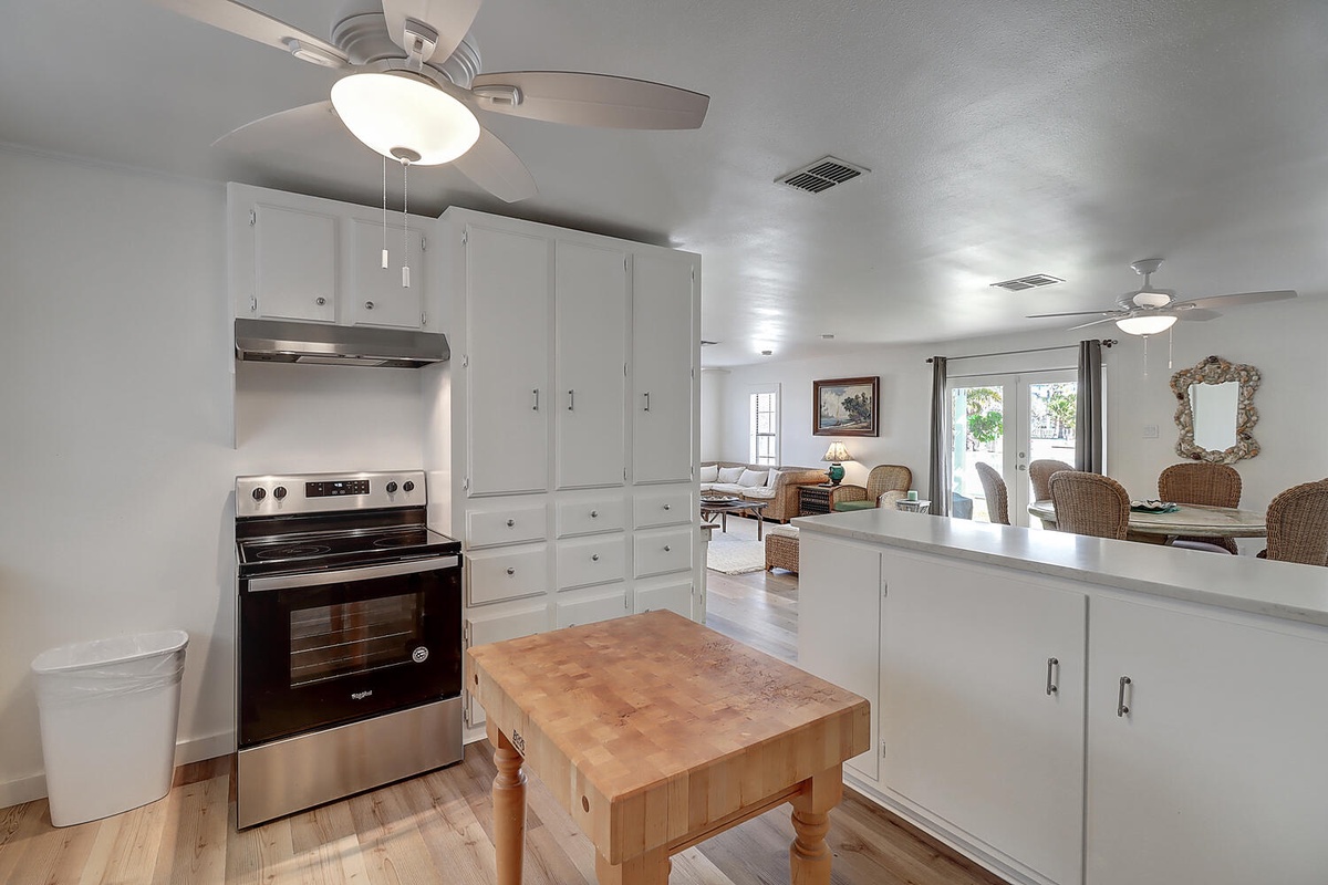 Your spacious kitchen features crisp white cabinetry, modern appliances, and flows seamlessly into the living area—perfect for cooking memorable meals together.