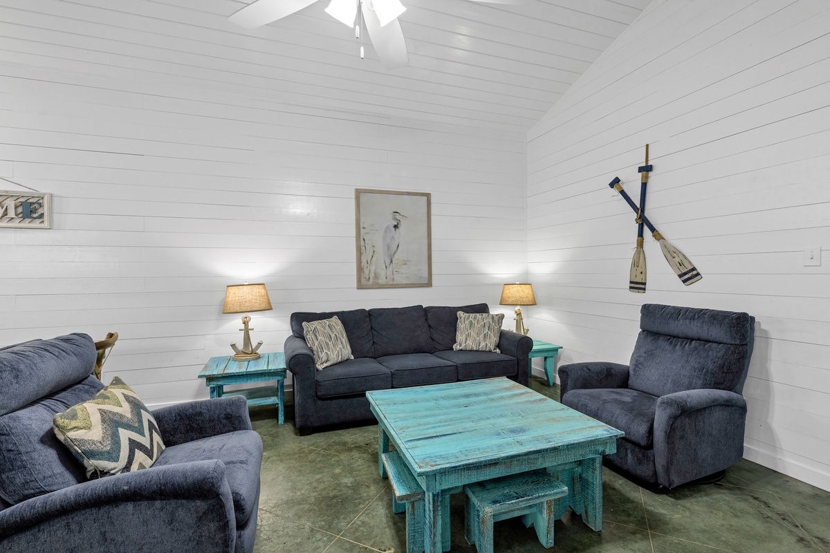 Sink into plush navy seating surrounded by charming coastal touches and shiplap walls for your perfect lakeside retreat.