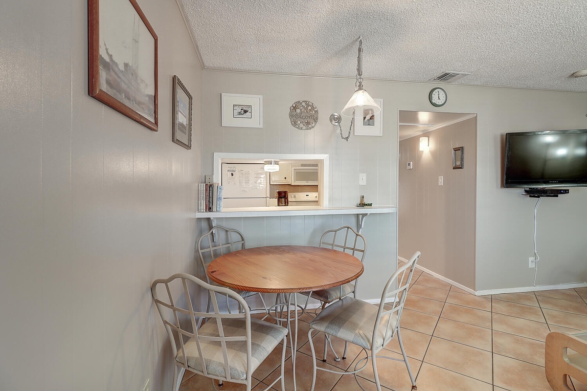 Gather around your cozy dining table for meals and memories, with the convenience of a full kitchen just steps away.