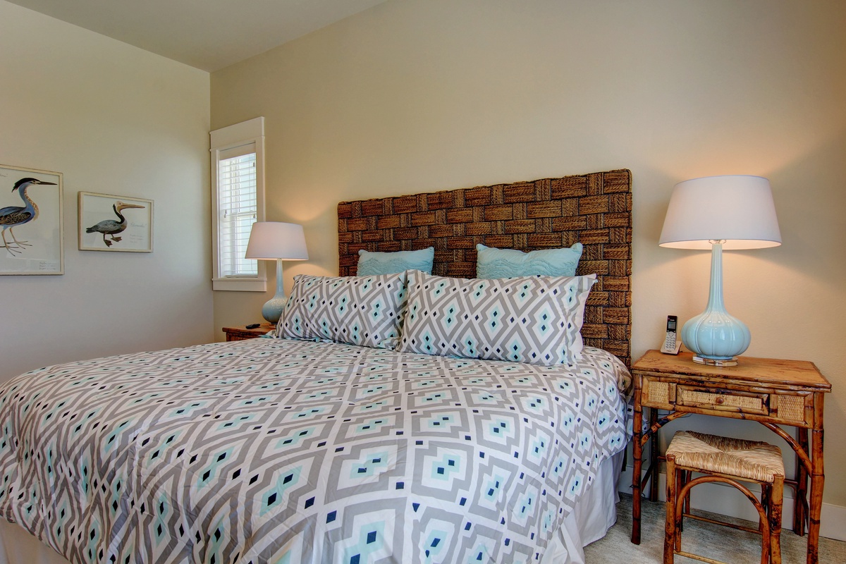Drift off in your cozy bedroom featuring a woven headboard, soft geometric linens, and warm lighting for peaceful nights.