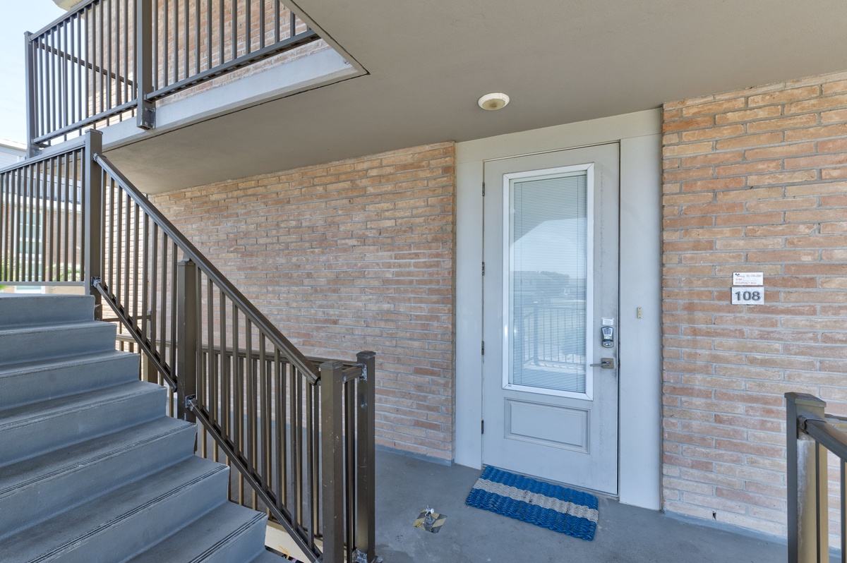 Modern brick facade with clear unit numbering and covered entryway provides a welcoming arrival experience.