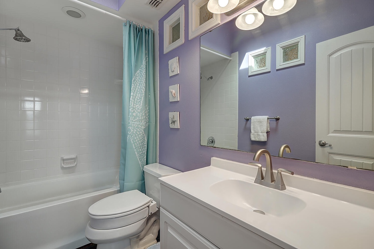Step into your stylish purple bathroom featuring a spacious shower-tub combo, elegant vanity, and thoughtful touches that make your daily routine feel luxurious.