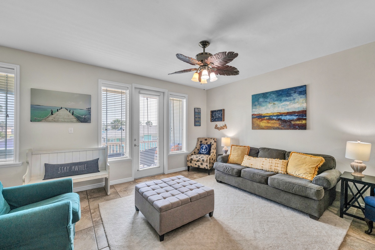 Relax in your bright, coastal-themed living room with comfortable seating and cheerful artwork welcoming you home.