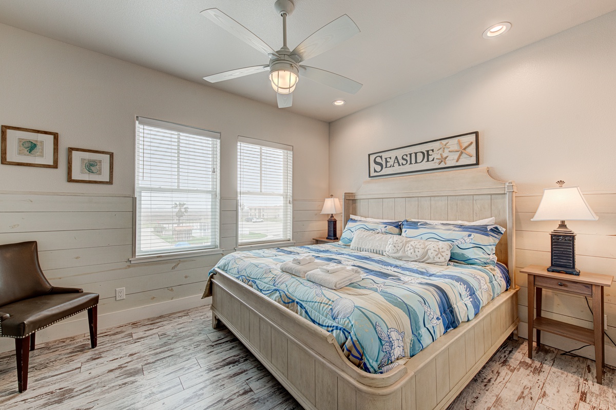 Drift off in your coastal-themed bedroom with ocean-blue bedding, nautical charm, and gentle ceiling fan breezes creating the perfect seaside retreat.