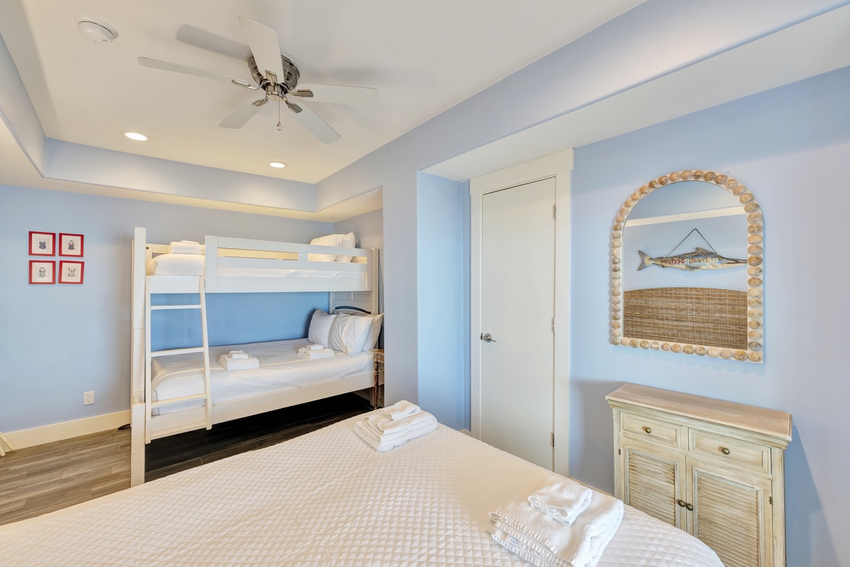 Unwind in your coastal-themed bedroom with crisp white linens and soothing blue walls that create a peaceful retreat.