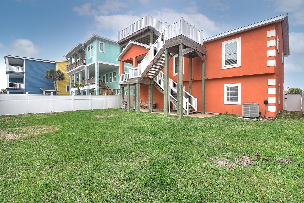 Vibrant beach houses create a colorful coastal neighborhood backdrop with private yard space and distinctive architecture.