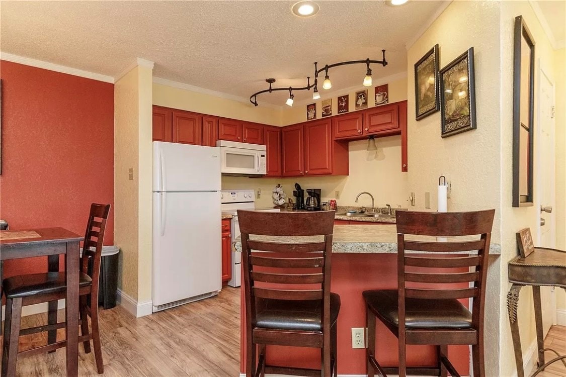 Your fully equipped kitchen features rich cherry cabinets, granite counters, and a breakfast bar perfect for morning coffee or casual dining together.