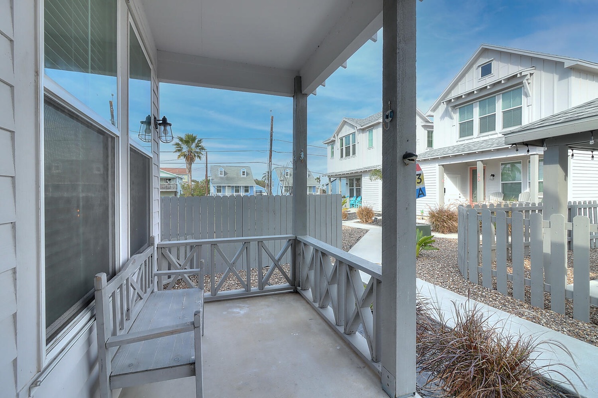 Relax on your private covered porch with charming coastal railings, where morning coffee feels perfect in this peaceful neighborhood setting.