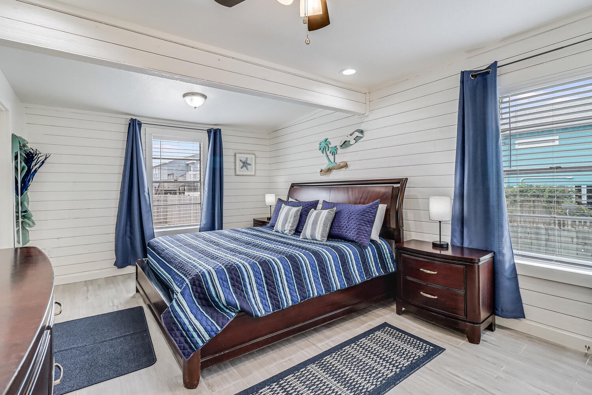 Sink into your comfortable bed surrounded by coastal charm and shiplap walls, where blue accents create a soothing retreat.