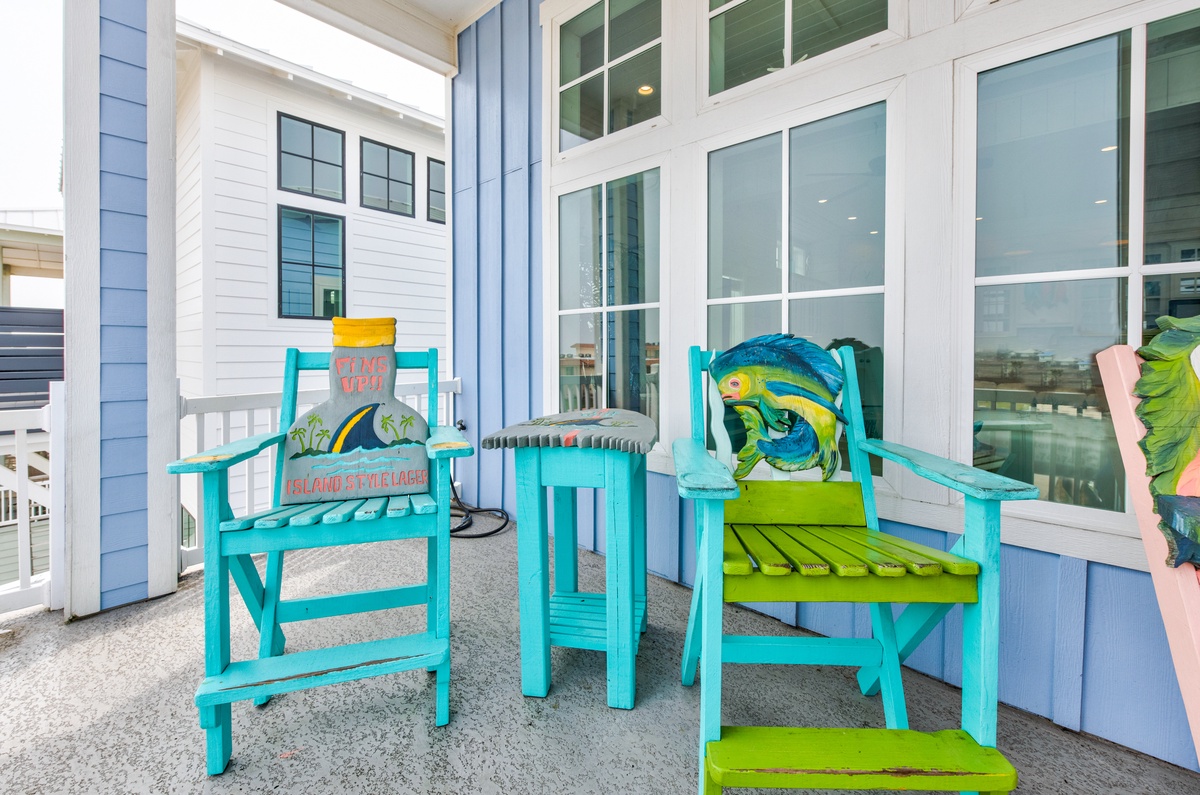 Sip your morning coffee on this cheerful turquoise porch set, where tropical fish artwork and vibrant island colors set the perfect beach house mood.