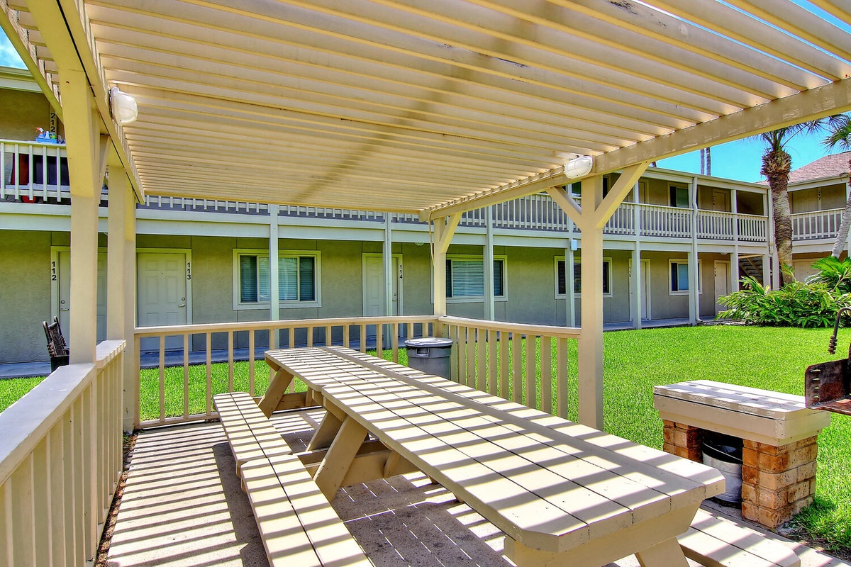 Your covered patio offers shaded comfort with picnic-style seating and a convenient grill for outdoor dining.