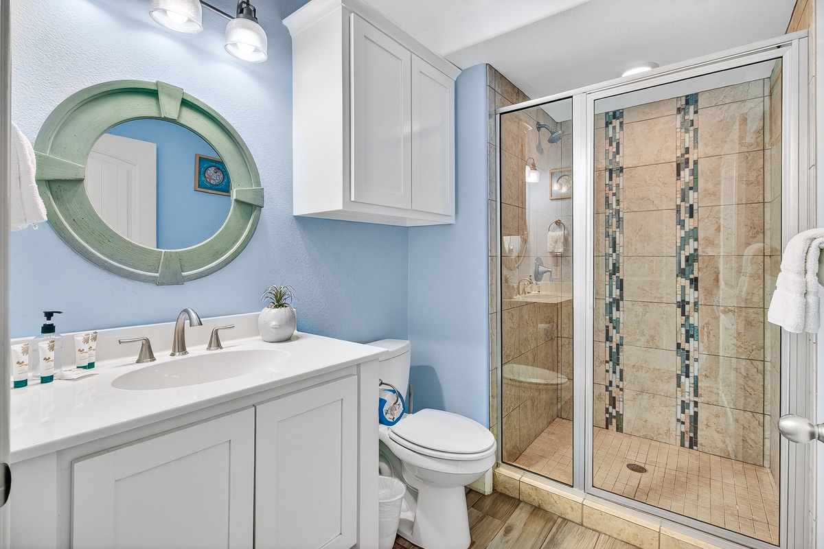 Refresh in your coastal-themed bathroom with spa-like shower, modern vanity, and beachy blue walls that create a serene morning routine.