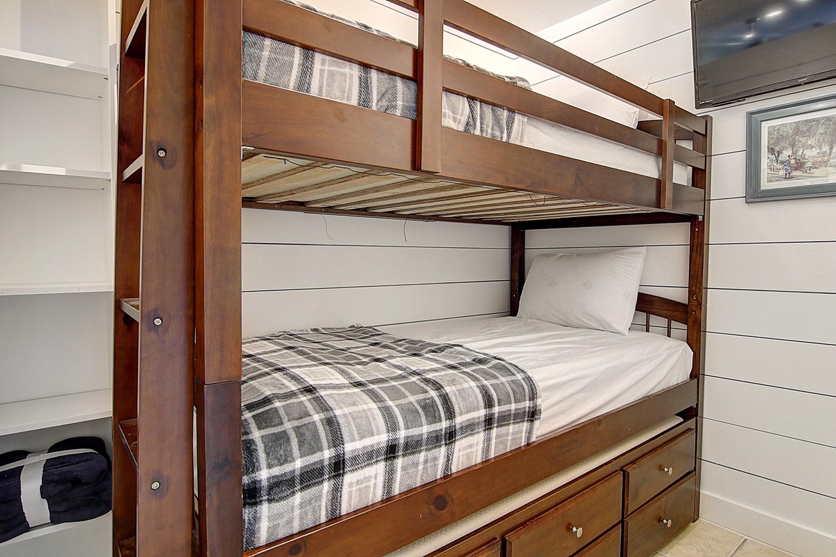 Sleep soundly in your cozy bunk bed with soft plaid blankets and built-in storage drawers beneath.